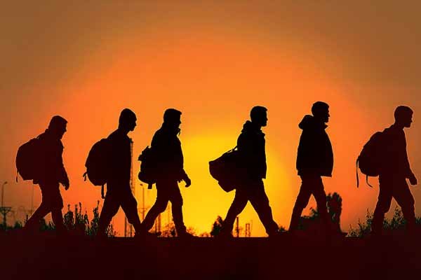 group of people walking across a field at sunset, highlighting the significance of Refugee Rights Day