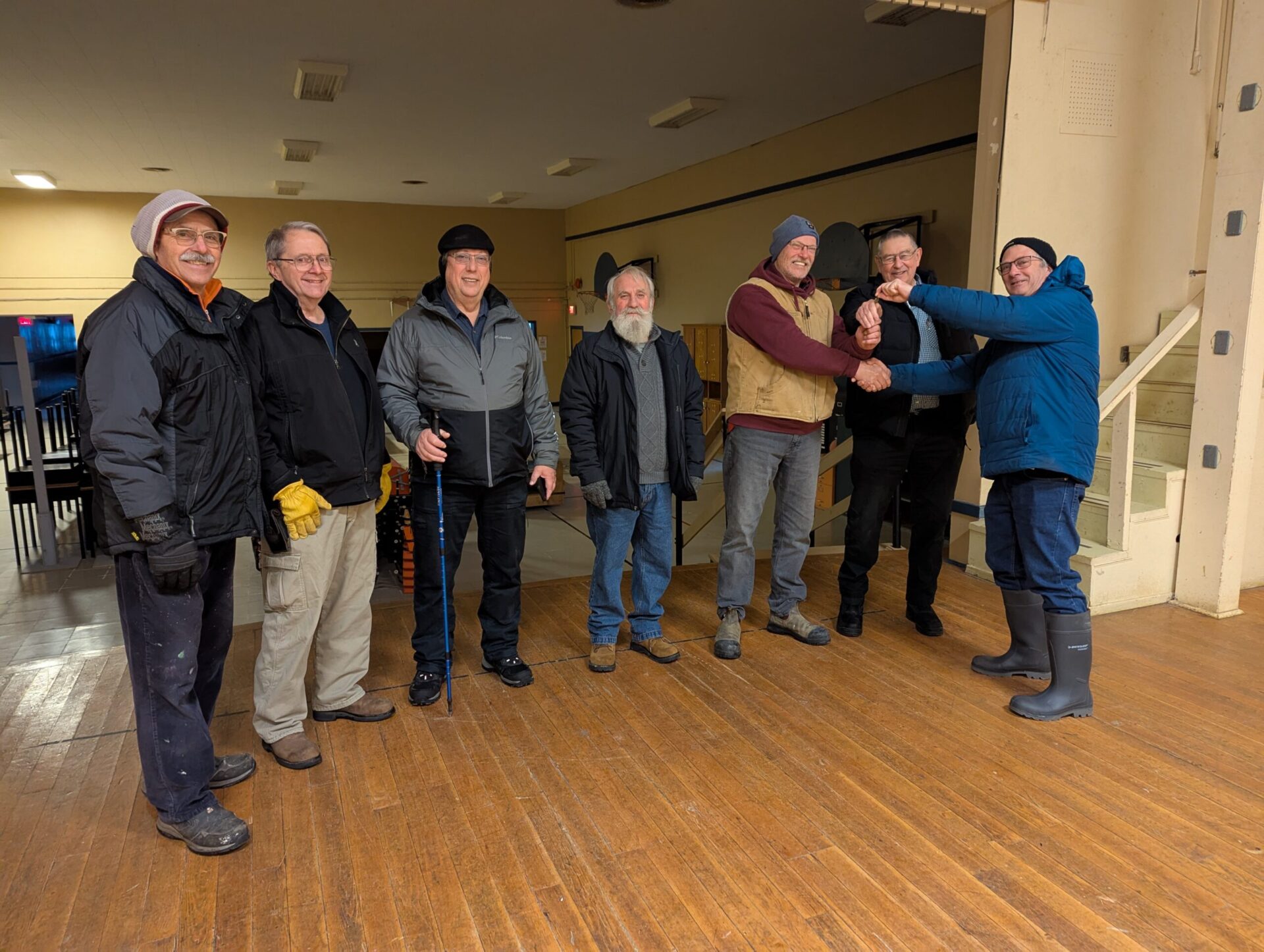 group of people standing on top of a hardwood floor