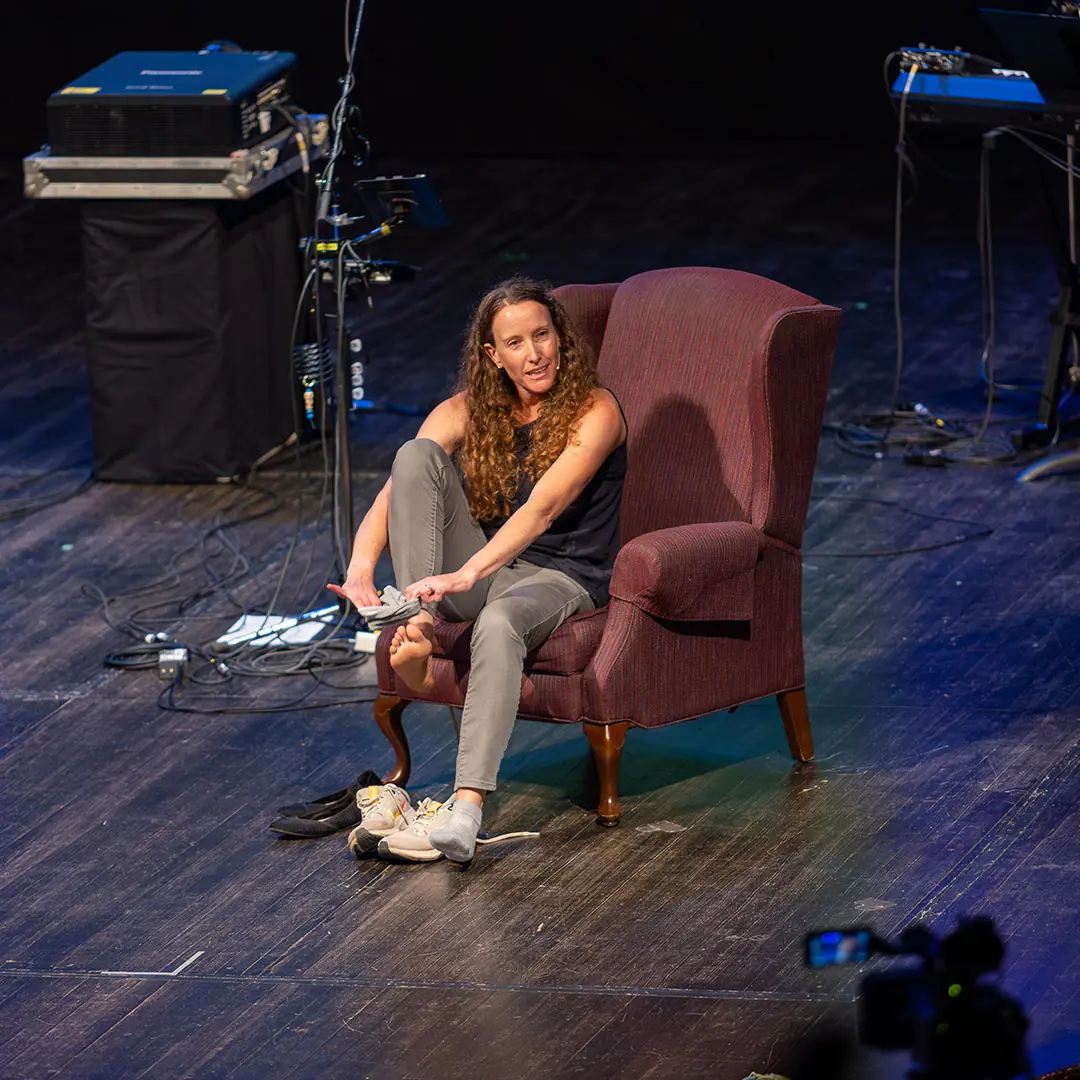 woman sitting in a chair on a stage